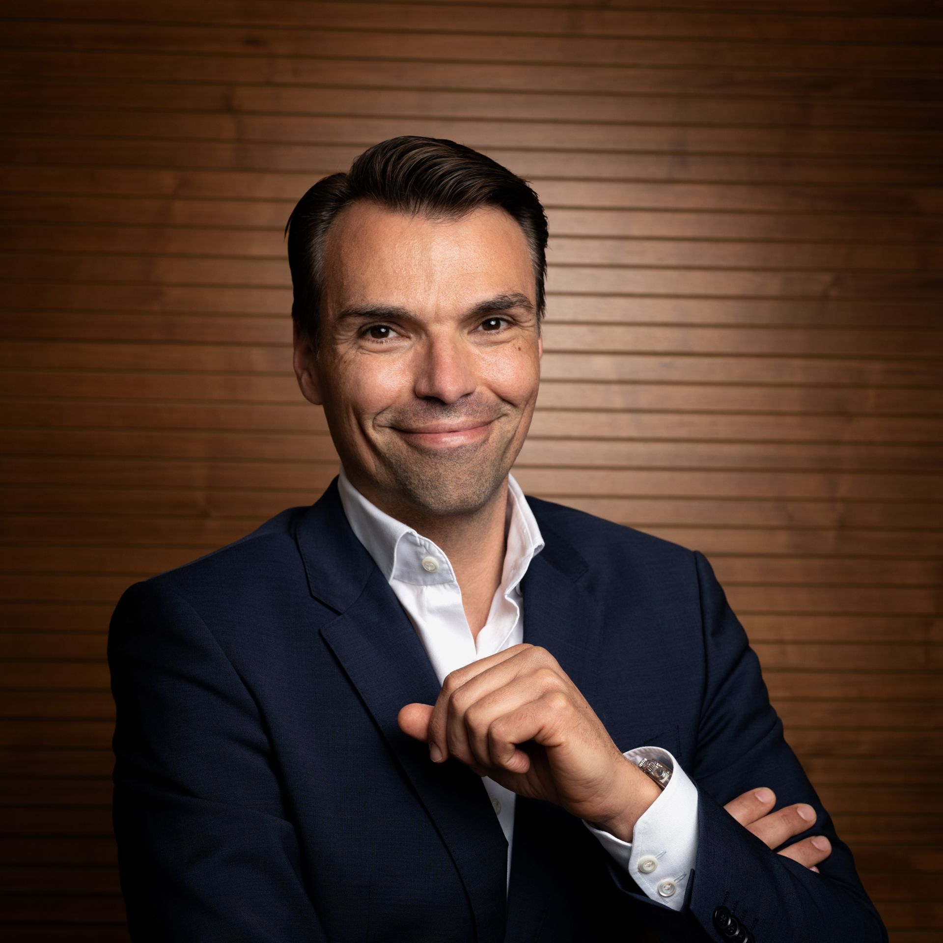 Ein Mann im Anzug lächelt freundlich in die Kamera.